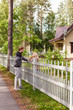 © Comeback Images - Middle aged man and his female neighbor standing in countryside and talking over wooden fence