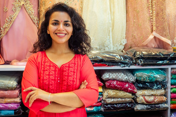 indian seller women in red kurta stand in her studio showroom