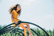 © Inti St. Clair - Happy girl sitting on top of jungle gym in playground