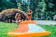 © Inti St. Clair - Girls playing on slip and slide in front yard of home