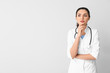 © Pixel-Shot - Portrait of young female doctor on light background
