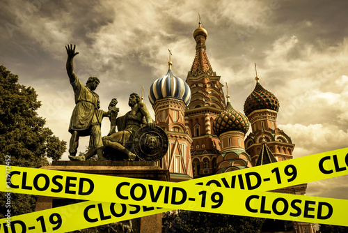 COVID-19 coronavirus in Russia, caution tape in photo of St Basil`s Cathedral, Moscow. World tourist landmarks closed due to corona virus outbreak.