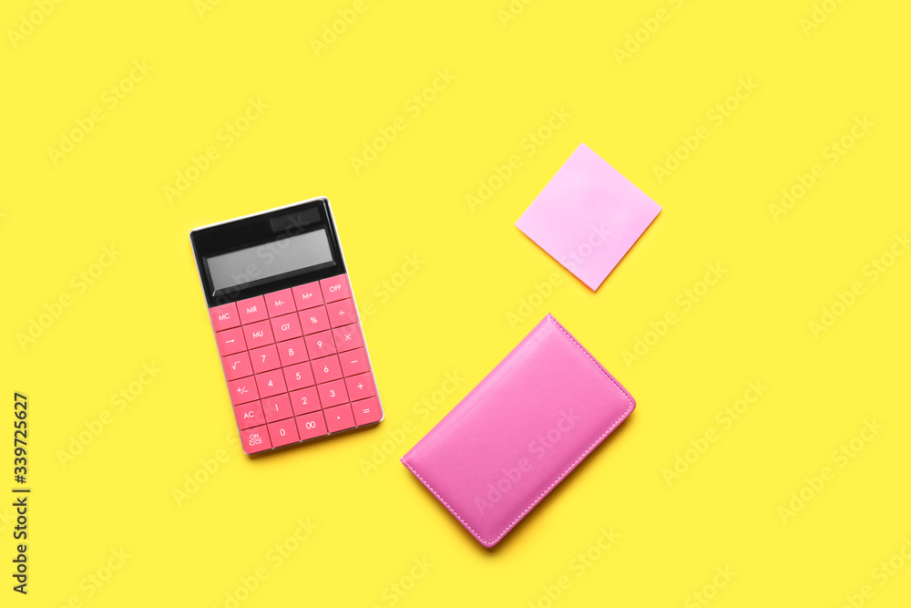 Modern calculator with stationery on color background