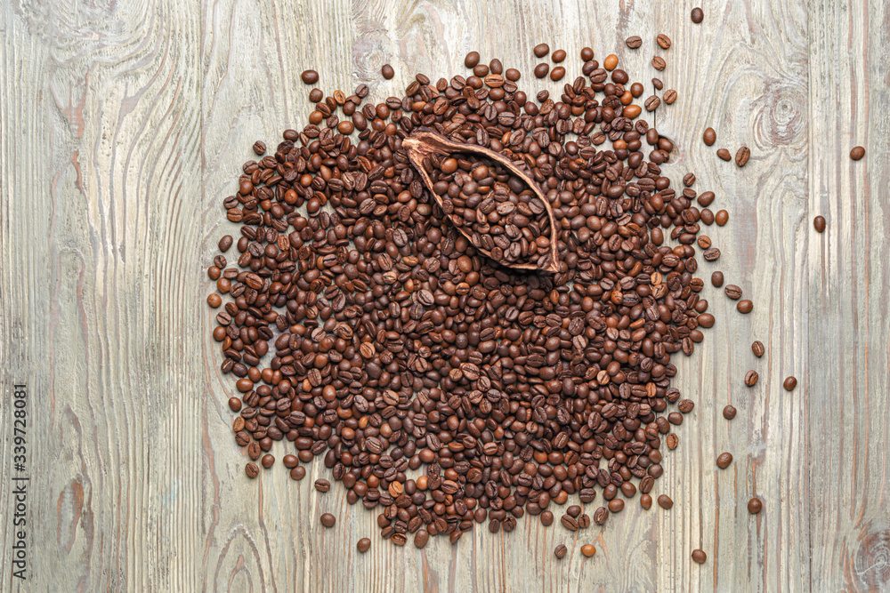 Many coffee beans with cacao pod on wooden background