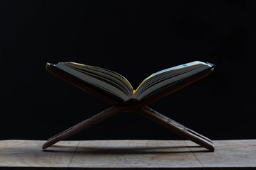 Koran, Muslim prayers on wooden floors in the mosque, dark background, space for messages