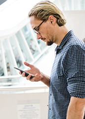 Poster - Blond man texting on his phone