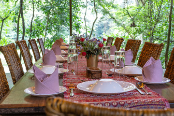 Poster - Served table and rattan chairs in an empty restaurant terrace. Tanzania, Africa