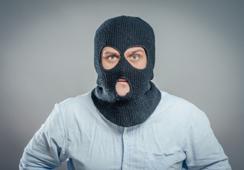 face of a angry burglar wearing a black ski mask or balaclava