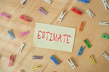 Handwriting text Estimate. Conceptual photo roughly calculate judge value number quantity extent of something Colored clothespin papers empty reminder wooden floor background office