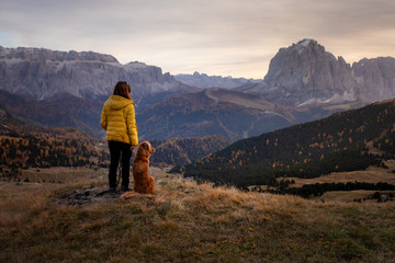 person with a dog in the mountains. travel, hiking with a pet. Nova Scotia retriever with a girl.