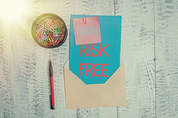 Wall Mural - Conceptual hand writing showing Risk Free. Concept meaning used to describe something that does not involve any danger Envelope letter sticky note ballpoint clips on wooden background