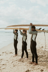 Canvas Print - Surfer team holding surfboards