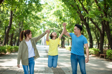 Wall Mural - Young asian family with child having fun in nature park