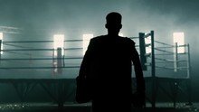 Dramatic Silhouette Of A Boxer Walking Towards A Boxing Ring In Slow Motion.