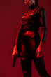 © LIGHTFIELD STUDIOS - cropped view of futuristic african american woman with gun isolated on red