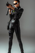 © LIGHTFIELD STUDIOS - futuristic african american woman in glasses aiming assault rifle on grey