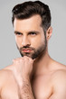 © LIGHTFIELD STUDIOS - pensive and shirtless man touching face isolated on grey