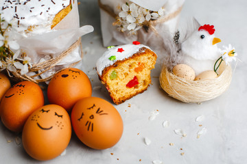 Glazed Easter cake decorated with colorful sprinkles. Complex decor of painted eggs and cherry blossoms. Top view, side view. Space for text.