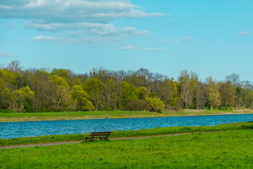 Wall Mural - lonely park bench on an idyllic river landscape