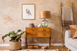© FollowTheFlow - Modern retro composition of living room with wooden vintage commode, furniture, lamp, plant, carpet, pillows, gold mock up poster frame, plants, decoration and personal accessories.