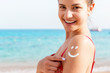© sosiukin - Sun cream over tanned woman's shoulder in the shape of smiling face