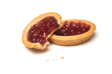 Wall Mural - Closeup of two crunched mini tartlets with strawberry jam on white background