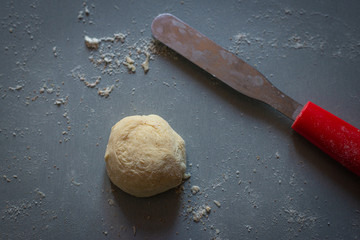  Bread dough  on floured board  with pallet knife.,making bread rolls at home.