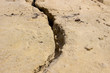 © OleJohny - Sand the dried earth. Cracks and collapses in the sand. The concept of barren land.