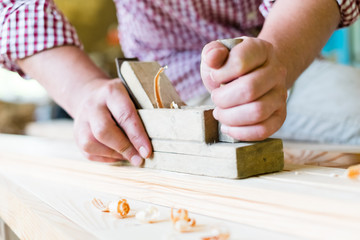 carpenter working  with  plane  on wooden background