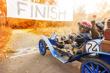 Young racer and mechanic on old race car