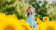 © sushytska - Little cheerful girl in a field of yellow sunflowers. Child and sunflower, summer, nature and fun. Summer rest