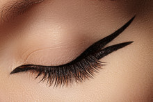 Beautiful Macro Of Female Eye With Fashion Black Eyeliner Makeup. Perfect Graphic Liner Shape. Cosmetics And Make-up