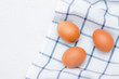 chicken eggs on a checked kitchen towel on a light table. concept of farm products and natural food. Article about home products. Fresh chicken eggs .