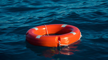 Life Buoy Or Rescue Buoy Floating On Sea To Rescue People From Drowning Man.