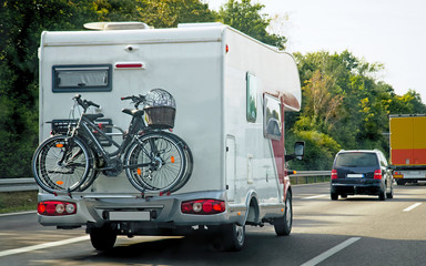 Canvas Print - Caravan with bicycles and cars in road at Switzerland reflex