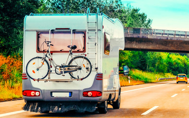 Canvas Print - RV Camper Car with bicycle on Road in Switzerland reflex