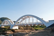 White Railway Bridge Over River Against Sky
