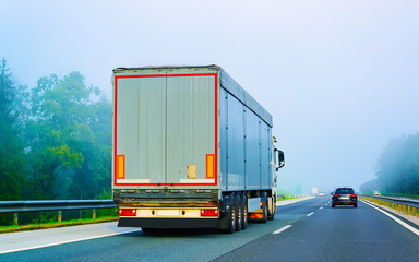 Canvas Print - Truck in asphalt road of Poland fog reflex