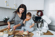 © sergiokat - happy family in the kitchen. mother and son preparing the dough, bake cookies