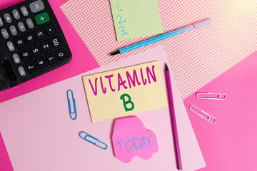 Conceptual hand writing showing Vitamin B. Concept meaning Nutrient that helps keep the body nerve and blood cells healthy writing equipments and plain note paper placed on the table