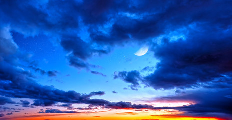 Wall Mural - dusk sunset sky and clouds landscape against bright star and half moon on blue universe background w