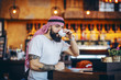 © Dusan Petkovic - Young handsome tattooed bearded muslim hipster sitting in cafe in the morning and drinking his coffee.