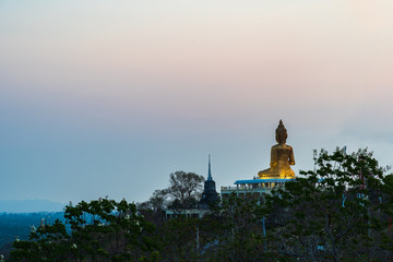 Wall Mural - Mountain Buddha statue surrounded by forest at sunset