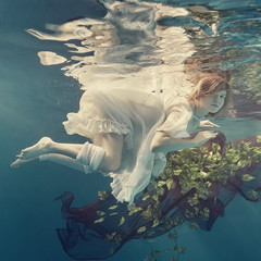 Wall Mural - Portrait of a girl floating underwater