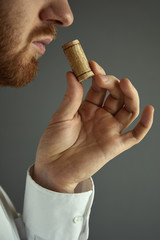 Close up image of sommelier examining smell of wine cork