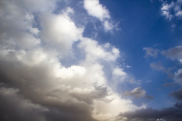 Clouds in the blue sky. A stunning gray sky. The storm is approaching. A beautiful clouds against the blue sky background. Amazing cloud pattern in the sky.