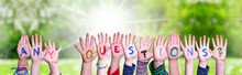 Children Hands Building Colorful Word Any Questions. Sunny Green Grass Meadow As Background