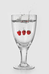 Wall Mural - glass of ripe fruit splashing into water