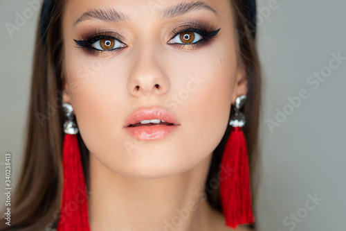 Cuadros en Lienzo Portrait of a young beautiful brunette woman with bright eye makeup