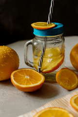 Wall Mural - Orange juice and whole oranges on a gray background
